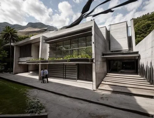 Diseño exterior de una residencia estilo mínimalista, con muros de concreto color blanco, perfiles con canal de acero en losa, ventanal de cristal en la parte superior del acceso, ventana en el estudi