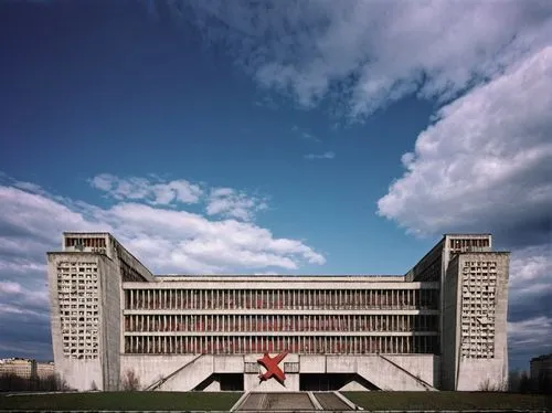 Soviet Bloc architecture, brutalist style, concrete building, grand scale, symmetrical composition, ornate details, hammer and sickle motifs, red star emblem, Moscow cityscape, cloudy sky, dramatic li