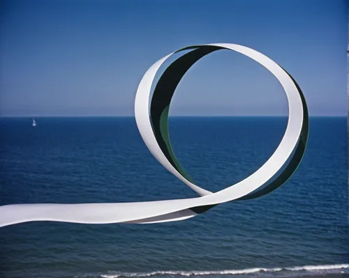 Visualize a ribbon gently swirling in a calm and serene ocean breeze.,circular ring,inflatable ring,torus,steel sculpture,circle shape frame,extension ring,semi circle arch,split rings,hoop (rhythmic 