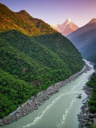 Confluence of two rivers Alaknanda and Bhagirathi give rise to the holy river of Ganga / Ganges at one of the five Prayags called Dev Prayag. Lush greenery in monsoons on the mountains. sunrise. India