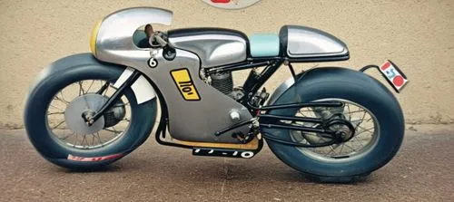 A 60´s racing motorcycle, single cylinder, faired, tail piece,a grey and black motorcycle parked in front of a building,bultaco,mignoni,kirkstead,velocette,gilera,dkw