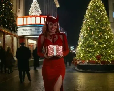 Make her dressed with a sexy Christmas red dress, in a Christmas Eve. She is holding a big Christmas present. The background is a facade of a classic cinema, in the centre, with Christmas tree and a l