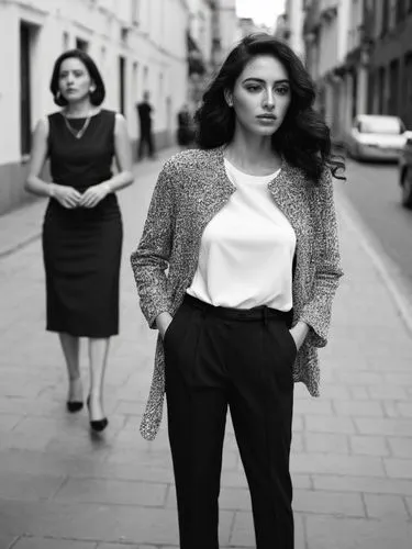 Two different women.,the girl in black is posing for the camera,business women,businesswomen,woman walking,chicanas,street shot,woman in menswear,Photography,Black and white photography,Black and Whit