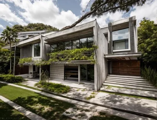 Diseño exterior de una residencia estilo mínimalista, con muros de concreto color blanco, perfiles con canal de acero en losa, ventanal de cristal en la parte superior del acceso, ventana en el estudi