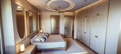 Bedroom with modern interior, decorative modern false ceiling, 4 door wardrobes opposite bed, wall art with lights and the door facing the camera leading into the bathroom and another next to the ward