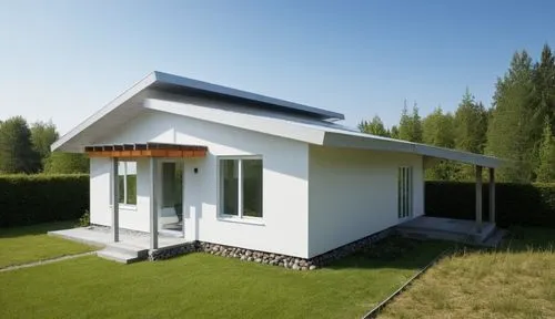 small modern house. The walls are white. Gray roof. There is a forest around the house.,an image of a house on a nice day,passivhaus,electrohome,greenhut,grass roof,inverted cottage,solarcity,Photogra