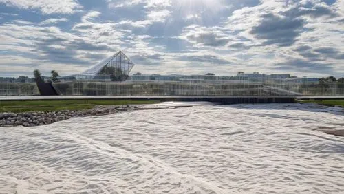 the sun is shining behind a building and a sand field,korean veterans memorial,birkenau,jasenovac,documenta,k13 submarine memorial park,shanksville,treblinka,christo,korean war memorial,majdanek,geote