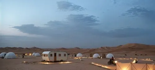 light color real wood rectangular caravan without wheels and windows ,a desert with several tents lit up at night,amanresorts,liwa,yurts,siwa,saliyah,bedouins