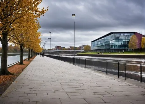 Stockton-on-Tees, architectural design, modern building, glass facade, steel structure, geometric shape, minimalist style, urban landscape, riverside location, Tees River flowing in background, autumn