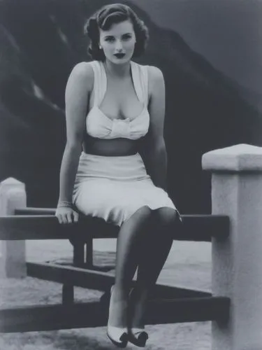 A lady from the 1940s in front of an Alpine backdrop.,an old black and white po of a woman sitting on a bench,ingrid bergman,jane russell-female,stanwyck,myrna,retro woman,maureen o'hara - female,Phot