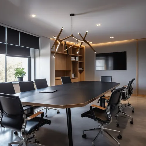 meeting room with white stucco walls and microcement flooring, with a table with a black lacquered top and dark wooden legs in the center, eight chairs with wheels with metal structure and seat and ba