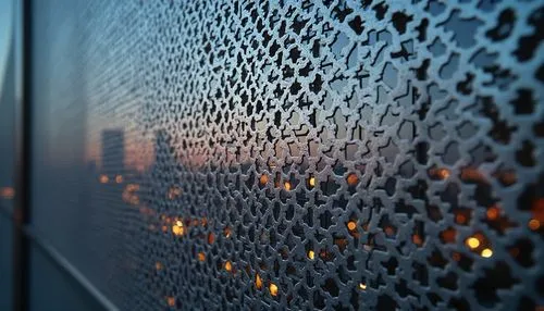 Perforated metal, industrial design, modern architecture, urban landscape, cityscape, skyscraper, metallic latticework, intricate patterns, silver-gray tone, reflective surface, evening ambient lighti