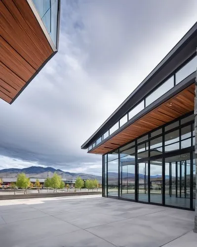 Modern architecture, Kamloops city hall, glass façade, steel structure, angular lines, asymmetrical composition, cantilevered roof, natural stone walls, wooden accents, floor-to-ceiling windows, minim