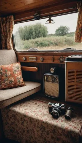 Retro-style camper van, cozy interior, wooden paneling, vintage curtains, floral patterned upholstery, plush cushions, antique metal lantern, warm beige carpet, distressed leather seats, classic radio