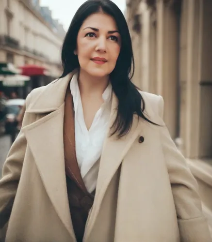 A woman with long black hair, dark brown eyes, and natural makeup,woman in menswear,businesswoman,business woman,paris,woman walking,trench coat,bussiness woman,overcoat,boeuf à la mode,coat,goura vic