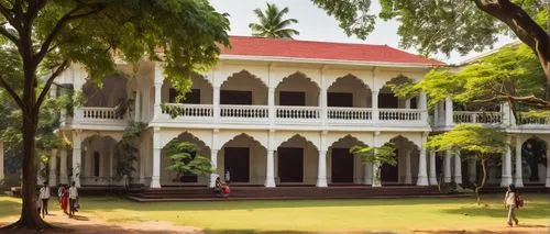 Chennai Academy of Architecture and Design, modern building, white columns, large glass windows, lush greenery surrounding, Indian-style architecture, intricate carvings, red-tiled roof, sprawling cam