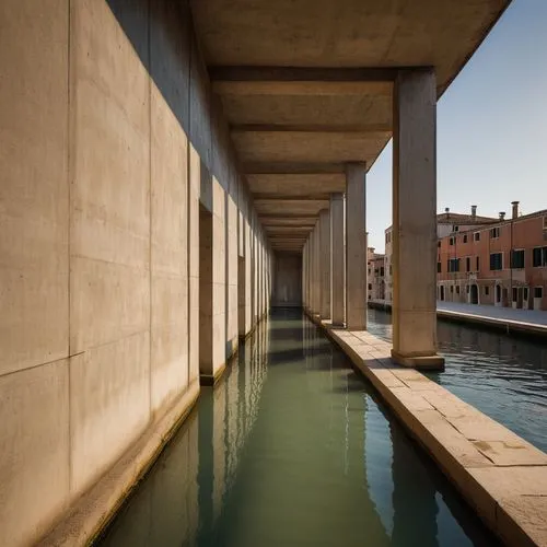 Carlo Scarpa, modernist architecture, brutalist design, geometric shapes, angular lines, raw concrete, industrial materials, minimalist interior, natural light pouring in, Venice, Italy, water canal, 