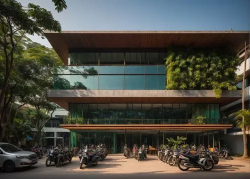 Modern architectural design company, Cambodia, Phnom Penh, bustling cityscape, sleek glass building, minimalist interior, wooden desks, ergonomic chairs, floor-to-ceiling windows, natural light pourin