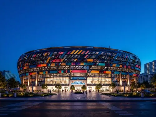 Modern stadium exterior, dynamic curved lines, sleek metal cladding, perforated panels, LED lighting strips, vibrant team colors, cantilevered roofs, grand entrance gates, urban cityscape backdrop, cl