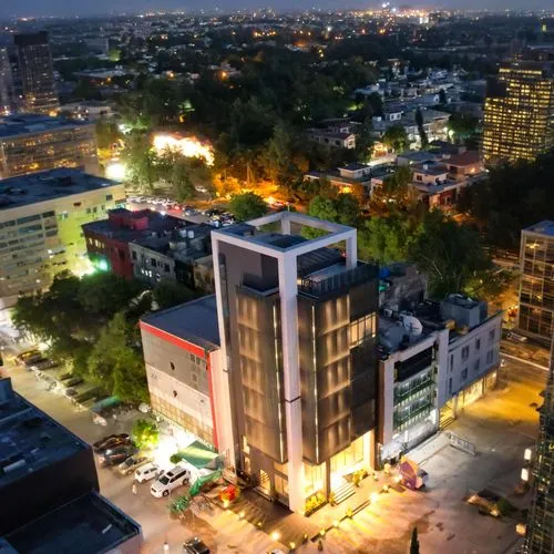 a night time cityscape showing a very tall building and some cars parked in front,dhaka,dhanmondi,yangon,penh,bashundhara,kinshasa,chittagong,bangalore,hcmc,legian,addis ababa,rajshahi,jadavpur,sangba