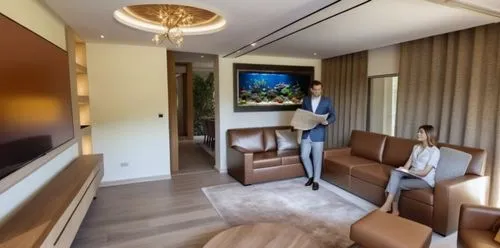 luxury fish tank with decoration, lights and a variety of fishes. the tank is flush with the wall and over looks the dining area on the backside,a woman standing next to a woman sitting on a couch,mod