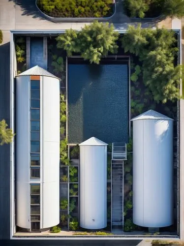 Modern silo architectural design, industrial-style building, symmetrical composition, rectangular shape, white concrete walls, large windows, steel frames, corrugated metal roof, cylindrical shape, ce