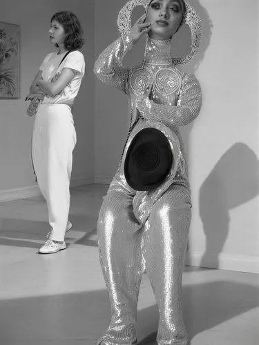 Two different women.,two women standing side by side, one wearing silver disco clothes,vyjayanthimala,yakimova,madhubala,signoret,nazimova,pyaasa,Photography,Black and white photography,Black and Whit