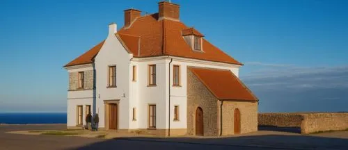 a large white house with brown roofs on the corner,rubjerg knude lighthouse,rubjerg knude,danish house,petit minou lighthouse,groix,pei,Photography,General,Realistic