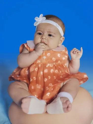  baby,a baby sitting in an orange dress is holding it's hands,diabetes in infant,newborn photo shoot,britton,baby diaper,babycenter,bebe,Photography,General,Realistic