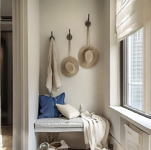 a bench sitting under two windows next to a couple of hooks,mudroom,window with shutters,wooden shutters,plantation shutters,entryway,entryways