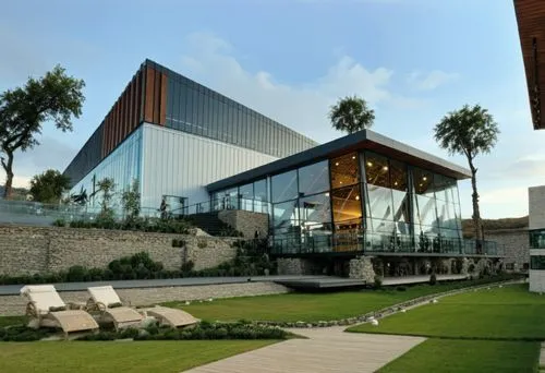 DISEÑO EXTERIOR DE UN RESTAURANT PARA UNA NAVE INDUSTRIAL, TERRAZAS PARA AREA DE COMENSALES YTERRAZAS CON MUROS DE PIEDRA ESCALONADOS, CON MUROS DE PIEDRA, PERSONAS EN LA ESCENA CAMINANDO,CESPED, VENT