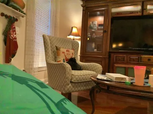 A cozy living room,blonde woman reading a newspaper,blonde sits and reads the newspaper,augmented reality,tea and books,little girl reading,armchair,blonde on the chair,staying indoors,slipcover,blond