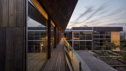 building reflecting the city lights on its glass skins at night. with woody panel. without water mirror.,corten steel,landscape design sydney,dunes house,modern architecture,landscape designers sydney