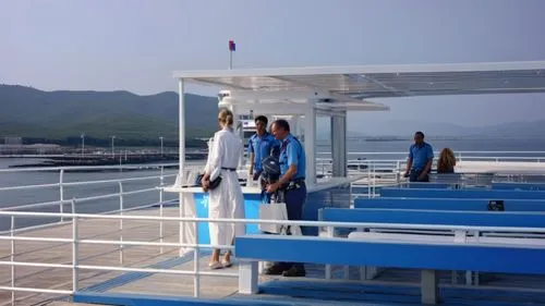 kiosco con barra para vender refresco, copteles, cafe, COCADA ubicada en la pare superior de uun ferry con detalles de un barco en la noche fotorealista CON PISO AZUL PASTEL, Y TECHO DE LONA TENASADO 