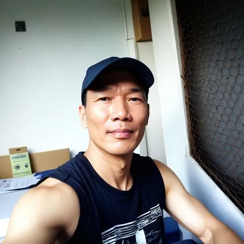 man sitting on top of a blue chair and wearing a black hat,junjie,azn,rental studio,in a studio,zhipeng,kwanchai