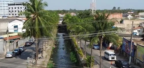 a stream passing between some trees on the street,chinsurah,mattancherry,tezpur,netrokona,mapusa,dehiwala,medinipur,douala,bhabanipur,bhawanipatna,kamrup,rangpur,bagbazar,monrovia,raiganj,barrackpore,