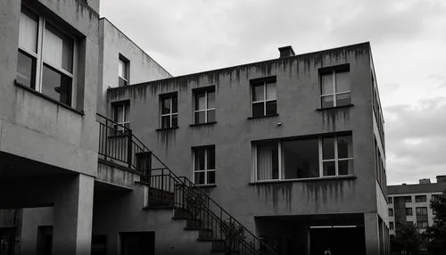 Monochromatic brutalist building, rugged concrete textures, bold geometric forms, dramatic shadows, industrial materials, urban cityscape, overcast sky, moody atmosphere, desaturated color palette, mu