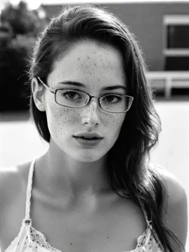 The same scene as a black and white photo. However, the freckles should be visible.,a woman in glasses stares into the camera,with glasses,silver framed glasses,glasses,dennings,eye glasses,eyeglasses