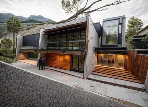 DISEÑO EXTERIOR DE UNA CASA RESIDENCIAL ESTILO MINIMALISTA, CON UN VENTANAL DE CRISTAL  EN EL AREA DE ACCESO PRINCIPAL, CANALES DE ACERO EN LA LOSA, ELMENTOS DE MADERA, MUROS COLOR BLANCO, COLORES NEU