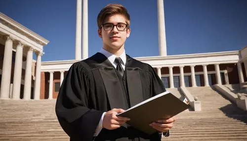 Young adult, male, bachelors of architecture degree holder, formal wear, black suit, white shirt, tie, glasses, short brown hair, beard, holding diploma, architectural model, background with universit