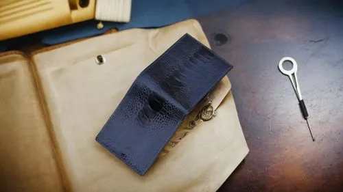 a blue wallet placed  upside down,there are many different items that can be found in this case,suturing,embossing,pinhole,leather goods,bookbinding,sewing tools