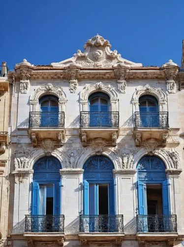 Marseille, French architecture, grandeur building, white stone façade, ornate decorations, columned entrance, arched windows, balconies with iron railings, red-tiled roof, Mediterranean landscape, blu