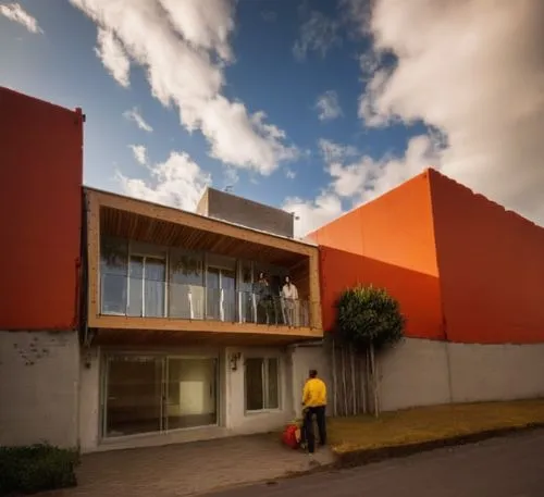 A minimalist-style house with bold, geometric patterns and a rustic wooden facade sits in the heart of a bustling city. The house features three unique hues of color - the light of a sunlit streetlamp