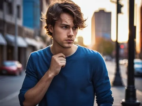 Young adult guy, casual wear, messy brown hair, bright blue eyes, slight smile, tapping forehead, confused expression, standing pose, urban background, city street, afternoon sun, shallow depth of fie