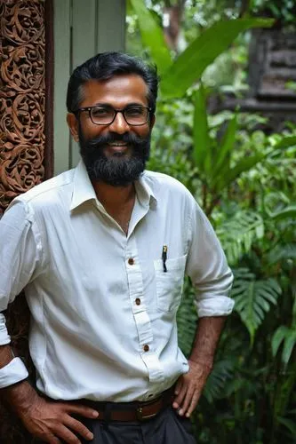 Middle-aged male, architect, designer, standing, Kochi city, India, traditional Kerala architecture style building, intricate wooden carvings, clay tile roof, large windows, greenery surroundings, lus