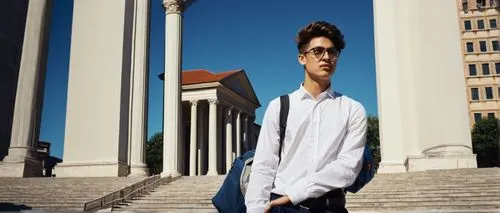 Young adult male, Bachelor of Design in Architecture, solo, (22yo), stylish hair, glasses, casual wear, white shirt, dark blue jeans, sneakers, holding a large portfolio, standing in front of a modern