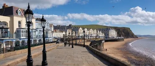 Weston-super-Mare, seaside town, British architectural style, Victorian-era buildings, Grand Pier, sandy beach, low-tide, sailboats, seagulls flying overhead, cloudy blue sky, soft natural light, warm