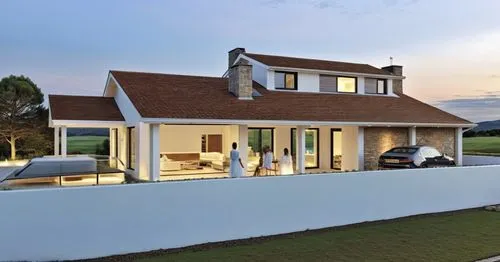 A modern, minimalist white house with clean lines and a few stone accents on the façade. The porch features white beams, complementing the sleek, minimalist design. The house is slightly elevated abov