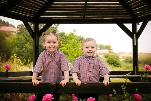 A landscape full of beautiful pink and red flowers,girl and boy outdoor,children's photo shoot,twin flowers,photo shoot children,grandchildren,gingham flowers,children's christmas photo shoot,barberto