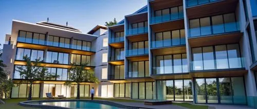 a large building with lots of windows is lit up,glass facade,townhomes,penthouses,inmobiliaria,lofts,multifamily,modern architecture,townhome,leaseholds,condominia,immobilier,glass facades,apartments,